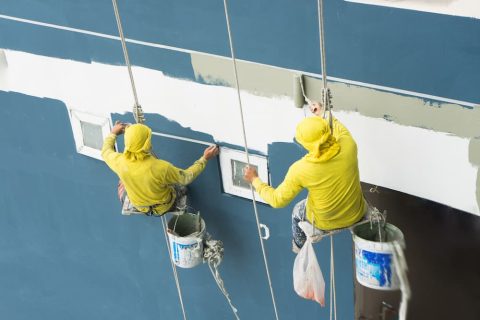 Professional painters on hoist painting exterior of large Brisbane apartment complex